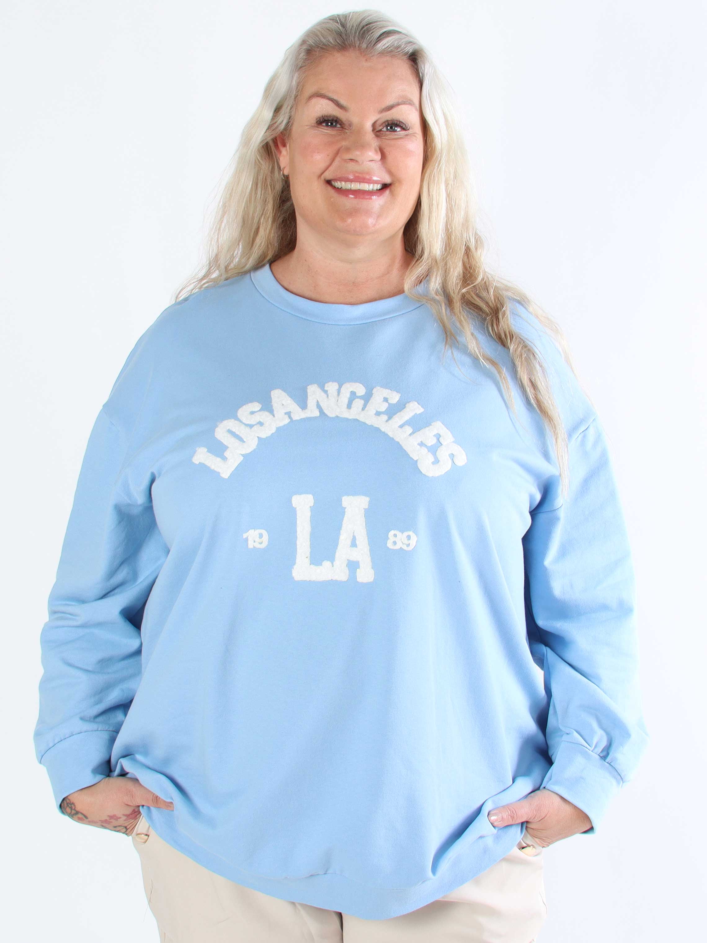 Magnolia - Plus size joggingtopp med LA skrivet i plysch